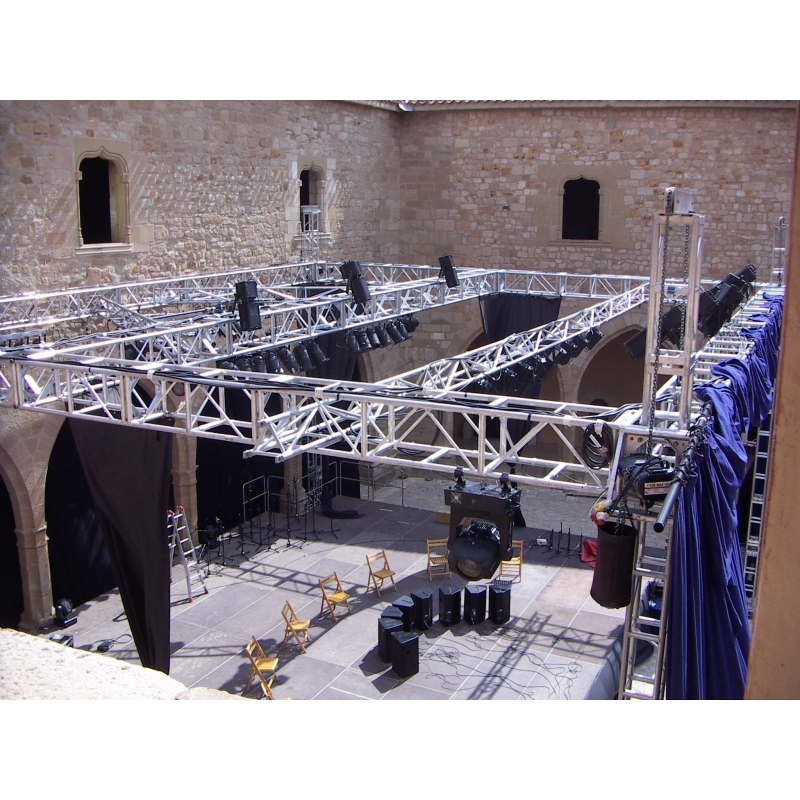 Estructuras de truss para teatro con focos de iluminación y telas escénicas dentro de un castillo